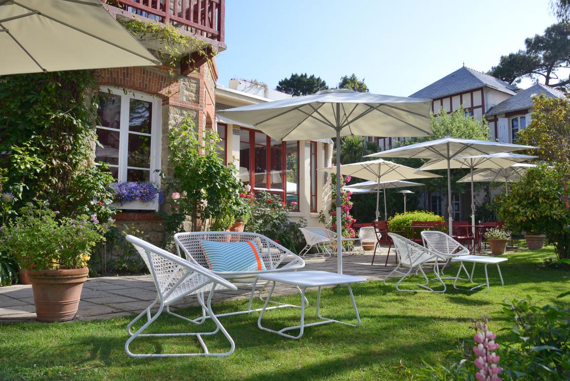 jardin verdoyant, mobilier blanc et parasols - hotel saint christophe