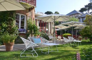 jardin verdoyant, mobilier blanc et parasols - hotel saint christophe