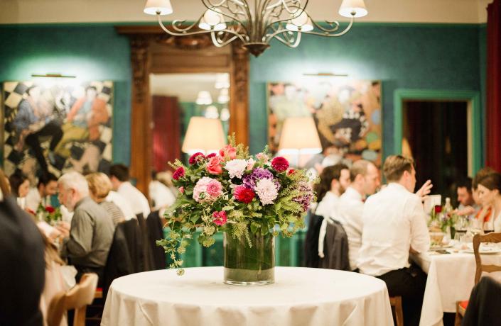 réception avec plusieurs invités et un bouquet de fleurs sur une table ronde - evenements la baule