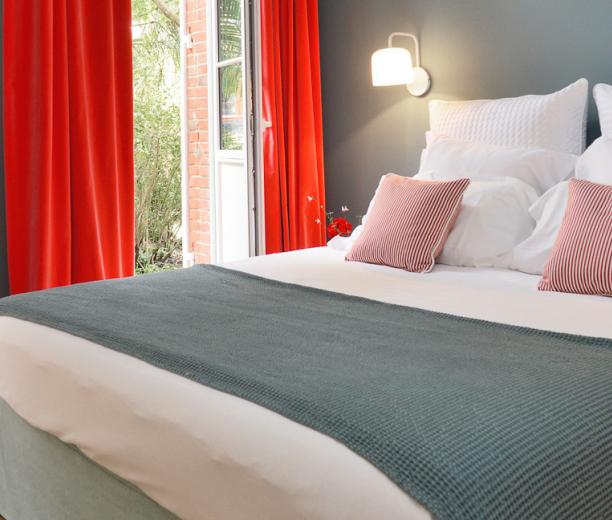 chambre moderne avec lit double et rideaux rouges - hotel la baule
