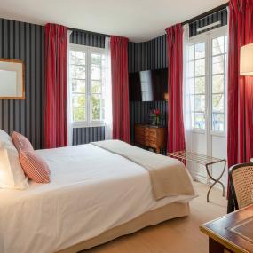 chambre sophistiquée avec décor rayé et rideaux rouges - hotel 4 etoiles la baule