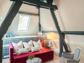 petit salon avec canapé rouge, une petite table et deux fauteuils - hotel la baule vue mer