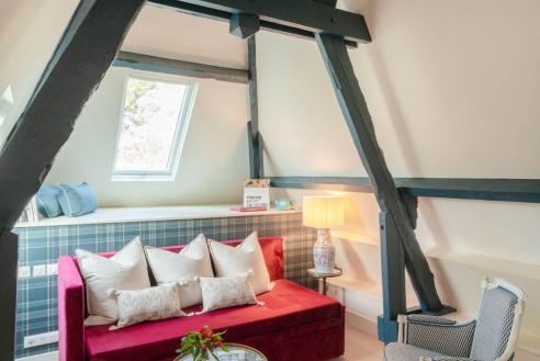 petit salon avec canapé rouge, une petite table et deux fauteuils - hotel la baule vue mer