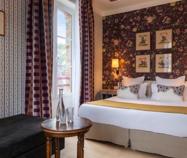 chambre d'hôtel avec motifs floraux et lit double - hotel 4 etoiles la baule