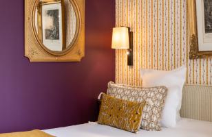 chambre avec mur prune et coussins dorés - hotel la baule