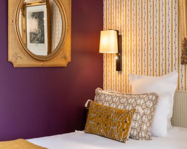 chambre avec mur prune et coussins dorés - hotel la baule