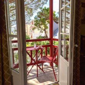 balcon, table rouge et vue sur le jardin - hotel la baule vue mer