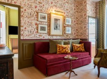 salon avec canapé rouge et tapisserie fleurie - hotel la baule vue mer