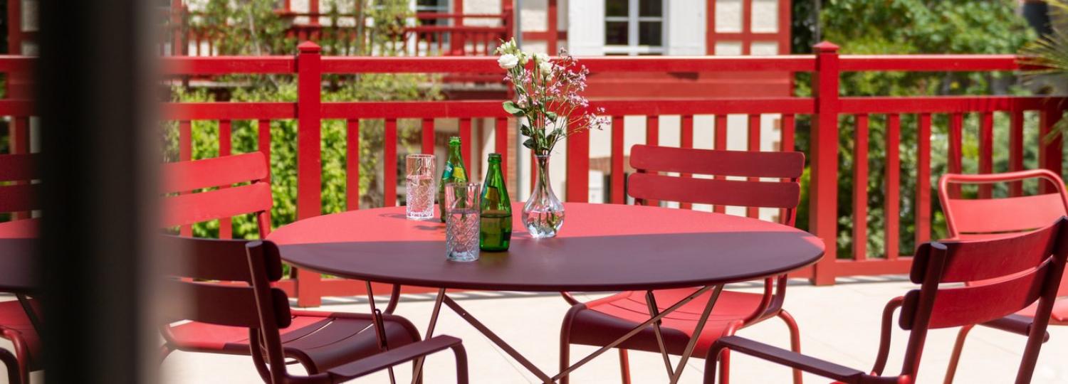 table et chaise rouge sur un balcon - hotel la baule vue mer